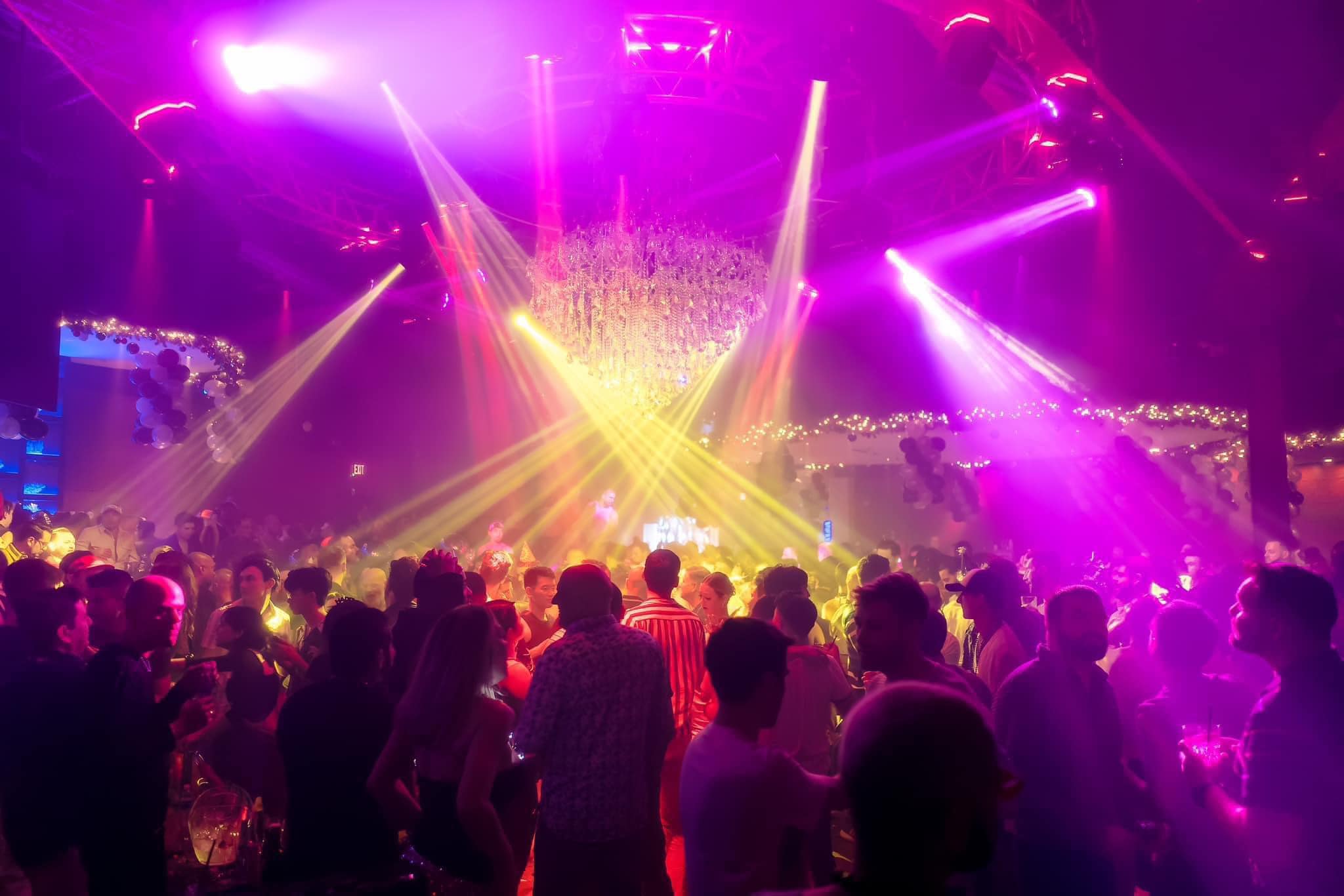 DJ mixing tracks with the laser array behind them